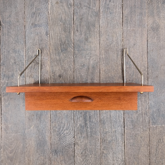 Etagère en teck à tiroir et supports laiton, Danemark, 1960 – vue de face – en teck, laiton – Danemark, années 1960 – Atelier 56
